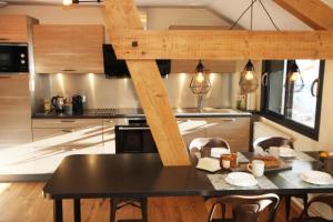 una cucina con tavolo nero e sedie di Le Grenier du 11 a Gérardmer Altre 9 foto