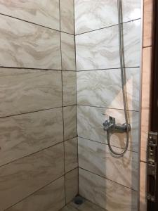 ブルサにあるSaray OTEL PANSİYONのシャワーヘッド付きのガラスドアが備わるシャワールームです。