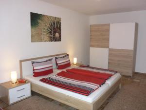a bedroom with a large bed with red pillows at Ferienwohnung Weyl in Eschbach