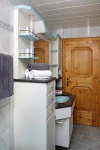 a bathroom with a sink and a wooden door at Rieserhof/Fam. Meißnitzer in Taxenbach