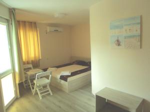 チェルノモレツにあるGuest house Kamburoviのベッド1台と椅子2脚が備わる小さな客室です。
