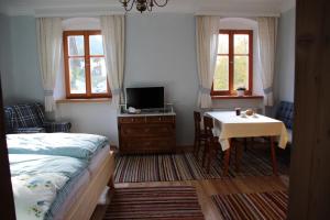 Un dormitorio con una cama y una mesa con televisión. en Stolznhof, en Schönberg im Stubaital