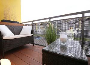 a balcony with a glass table and a chair at Apartimento Naturale in Wrocław