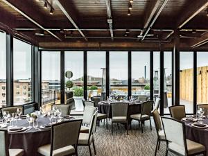 een restaurant met tafels en stoelen en grote ramen bij Hotel Goodwin in Beloit