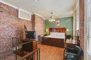 a bedroom with a bed and a brick wall at Grenoble House in New Orleans