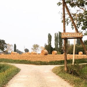 a dirt road with a sign in the middle of a field at B&B Cascina Sagrestia in Asola