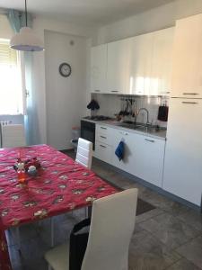 cocina con mesa y cocina con armarios blancos en L'Alloggio Perfetto, en Putignano