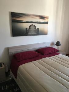 una camera da letto con un grande letto con sopra un dipinto di L'Alloggio Perfetto a Putignano