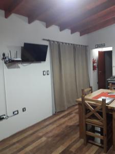 a dining room with a table and a television on the wall at Departamento Teodelina in Quehué