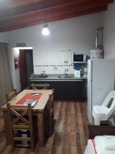 a kitchen with a wooden table and a refrigerator at Departamento Teodelina in Quehué
