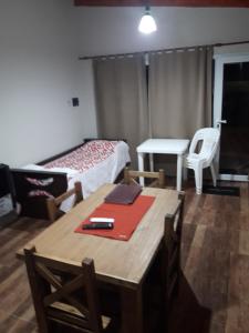 a room with a table and a bed and a desk at Departamento Teodelina in Quehué +15 photos