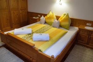a bedroom with a large bed with yellow and yellow pillows at Rieserhof/Fam. Meißnitzer in Taxenbach