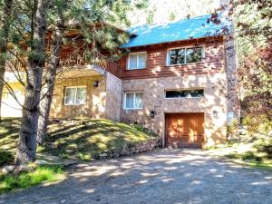 a stone house with a garage in the driveway at Villa Gutierrez Braun in San Martín de los Andes