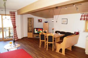een woonkamer met een tafel en een bank bij Haus Gaby in Holzgau