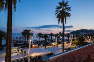a view of a city at night with palm trees at Guest House Imperial in Split