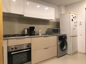 a kitchen with a refrigerator and a washing machine at Ghica Tei Studio in Bucharest