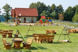 a park with a playground with wooden tables and benches at WJM Jagodne Wielkie in Miłki