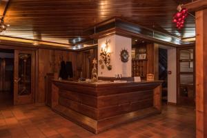 une boutique avec un comptoir dans une pièce aux murs en bois dans l'établissement Al Sole Hotel Ristorante dal 1870, à Pieve di Cadore