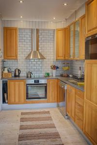 uma cozinha com armários de madeira e um forno com placa de fogão em Solbacka em Nybro