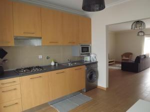 a kitchen with a stove and a washing machine at EntreCubos Guesthouse in Olhão