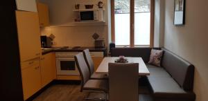 eine kleine Küche mit einem Tisch und Stühlen in einem Zimmer in der Unterkunft Ferienwohnungen Trinker in Ramingstein
