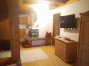 a living room with a tv and a dresser with a television at Bauernhof Hintenberg in Itter