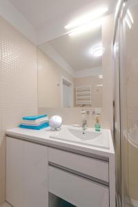 a white bathroom with a sink and a mirror at Apartament DeLux Marina in Kąty Rybackie +48 photos