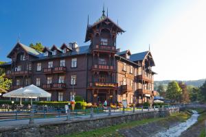 un gran edificio marrón con una torre de reloj en Pensjonat Witoldówka, en Krynica-Zdrój