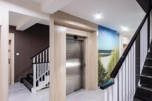 a hallway with a glass door and a staircase at Apartament DeLux Marina in Kąty Rybackie