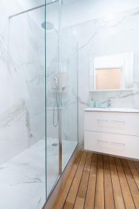 a white bathroom with a shower and a sink at Dreamyflat - Champs Élysées in Paris