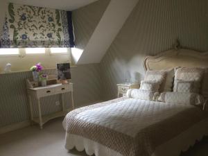 1 dormitorio con cama blanca y ventana en Le Clos des Roys en Reims