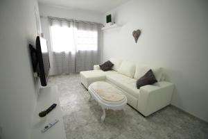 a living room with a white couch and a tv at COTILLO SEA in Cotillo