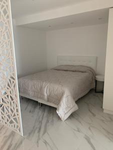 a small bedroom with a bed and a mirror at SYRAH Vistas by depptö in Punta del Este