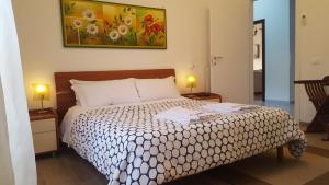 a bedroom with a bed and two lamps and a painting at Rome Apartment D'Amata in Ciampino