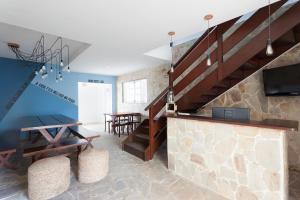 a living room with a staircase and a tv at BRECHA HOSTEL & ROOFTOP - Maragogi in Maragogi