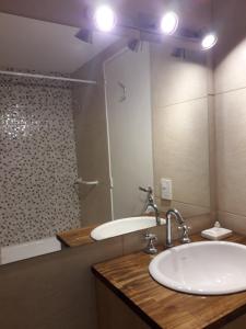 W łazience znajduje się umywalka, wanna i lustro. w obiekcie Patagonia Suite w mieście Bariloche