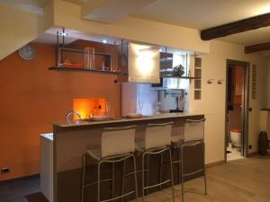 a kitchen with a bar with bar stools at Ancient walls home in Genoa