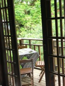 una puerta abierta a un patio con mesa y sillas en Buganville Loft, en Abraão