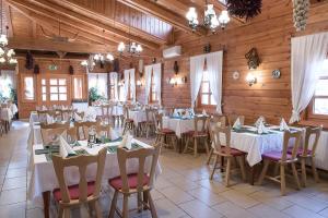 a dining room with tables and chairs and wooden walls at MeDoRa Park - Hotel MeDoRa*** in Gárdony