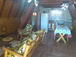 a living room with a table and a dining room at Recanto Mauá - Chalé Azaleia in Visconde De Maua