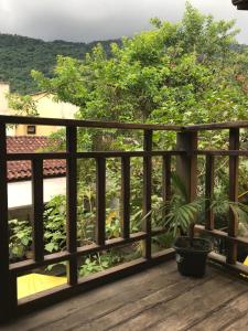 una terraza de madera con una maceta. en Buganville Loft, en Abraão