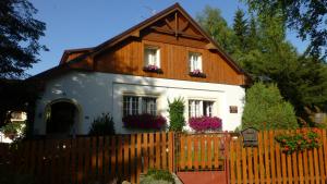 a house with a wooden fence in front of it at U Votápků in Nové Hutě
