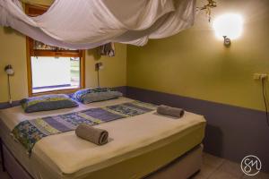 1 dormitorio con 2 camas en una habitación con ventana en De Plantage en Tamanredjo