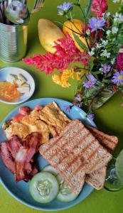 un plato de comida con tocino y tostadas en una mesa en Island Girl Bed and Breakfast, en Moalboal