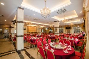 a banquet hall with red tables and chairs and chandeliers at Grand Wonderful Hotel in Sibu