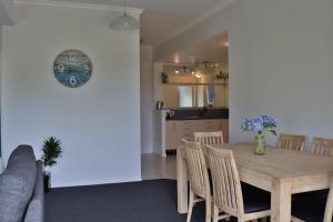 a dining room and kitchen with a wooden table and chairs at A Bay's Eye View in Paihia