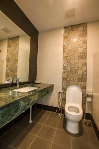 a bathroom with a toilet and a sink at Grand Wonderful Hotel in Sibu