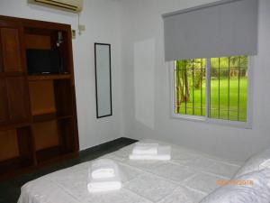 Habitación blanca con cama y ventana en Cabañas Los Girasoles en Gualeguaychú