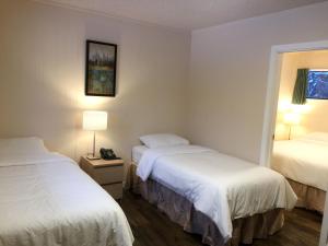 a hotel room with two beds and a window at The Hitching Post Motel in Pemberton