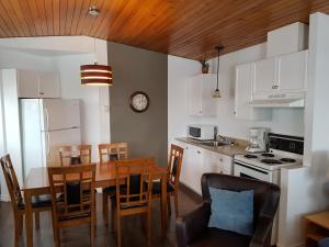 a kitchen with a table and a dining room at Motel Le Riviera in La Malbaie